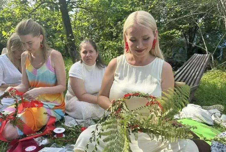 Гостьи фестиваля плетут венки из трав и цветов в усадьбе Бабушкина Хата